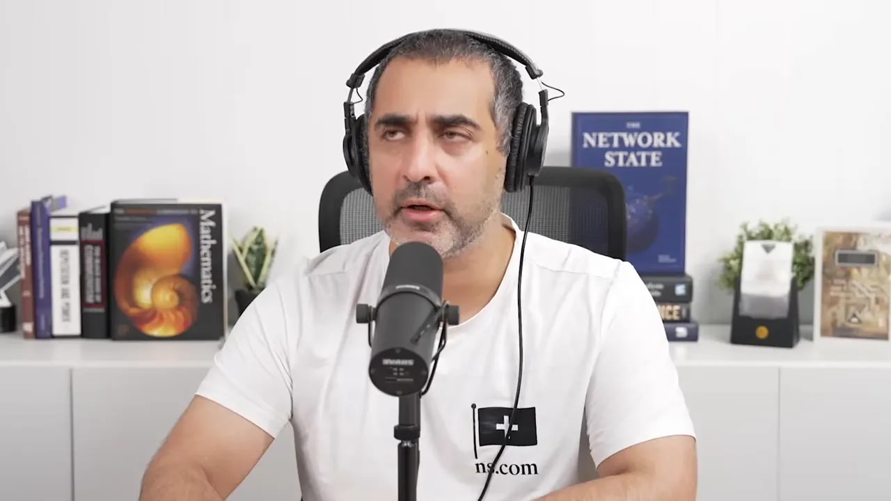 Balaji speaking into a microphone in a studio setup with headphones