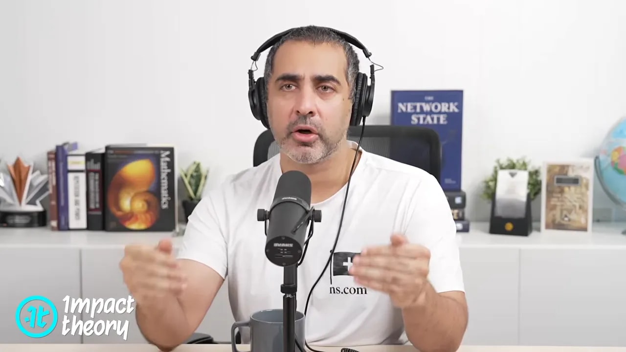 Podcast-style host wearing over-ear headphones and speaking into a microphone with both hands gesturing