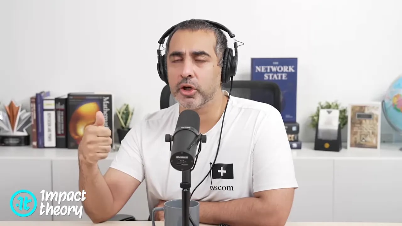 Podcast host giving commentary and gesturing while speaking into a microphone with headphones in a studio